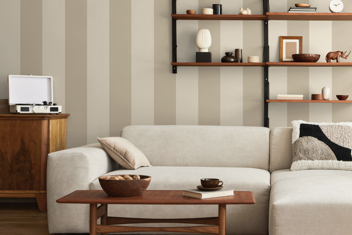 A beige sofa with Cordelia Stripe beige wallpaper