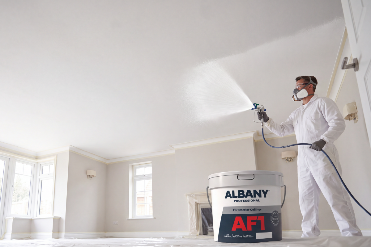 Decorator spraying Albany AF1 paint on a ceiling