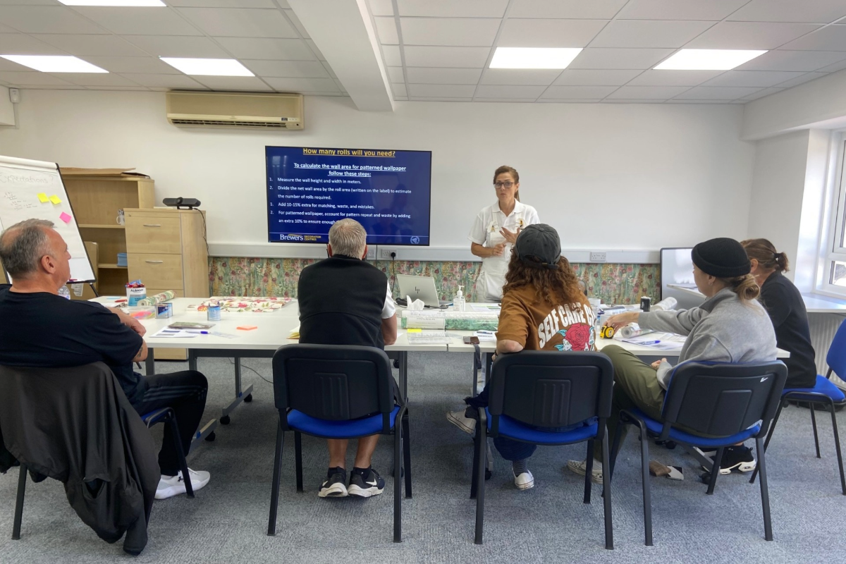 A group listening to the course leader in the training classroom