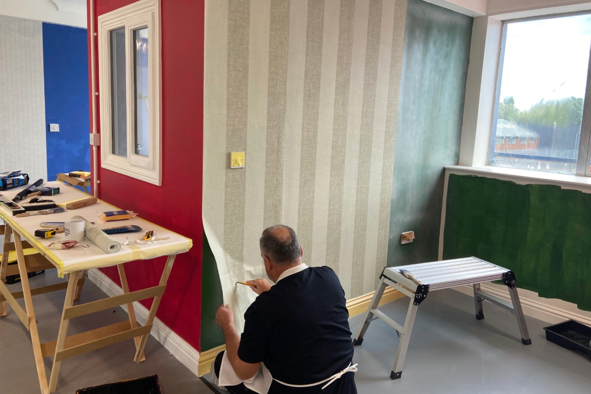 Course delegate pasting wallpaper to a wall