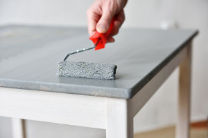 Applying a second coat of paint to furniture helps give an even finish.